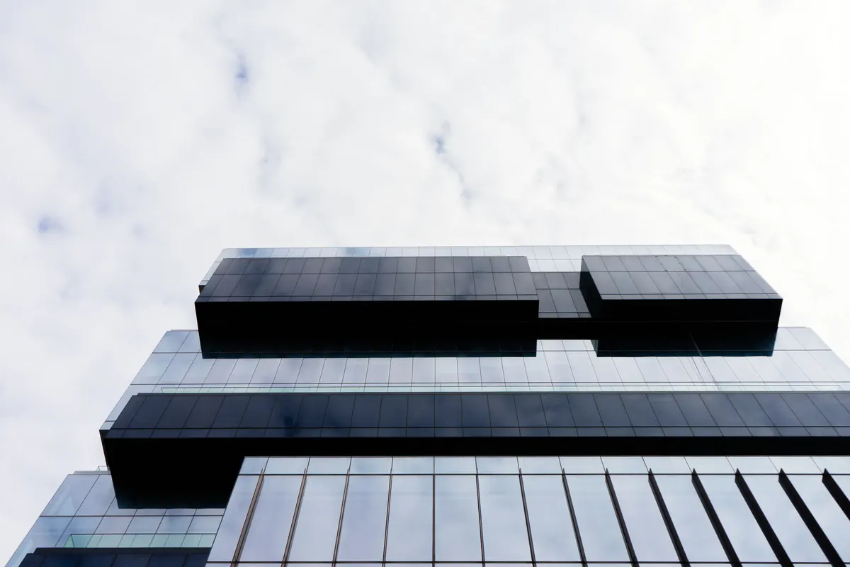 Prédio corporativo com fachada de vidro contra o céu, em dia claro